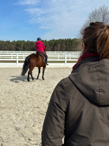 Eine Pferd-Reiterpaar wird auf einem Aussenreitplatz von Pferdetrainerin Kathi Stec unterrichtet.